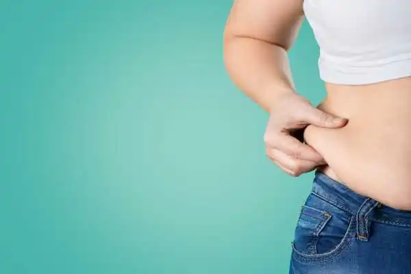 Image of woman pinching her love handles to show weight gain Newbury